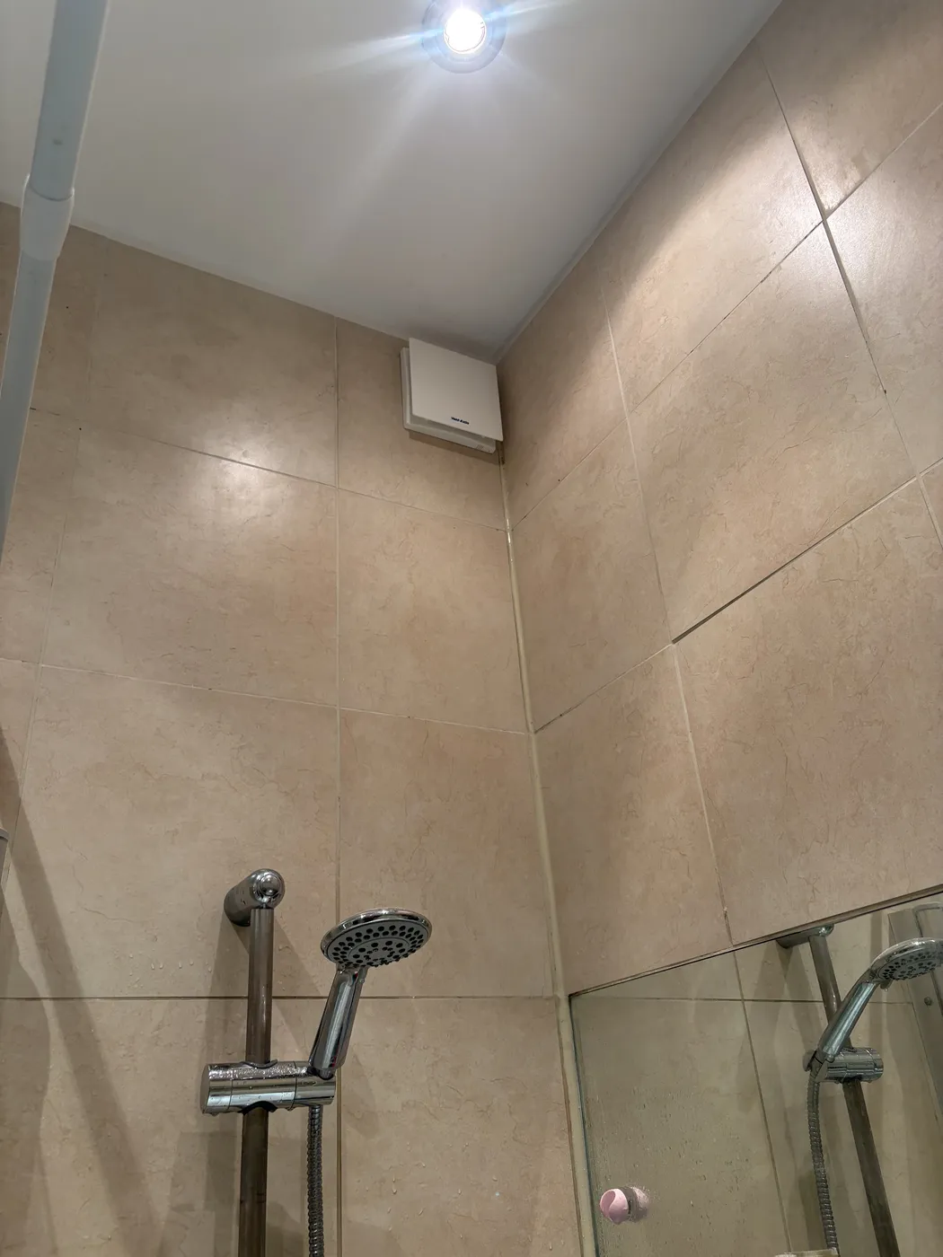 Bathroom extractor fan and downlight installed in a tiled shower area in Acton
