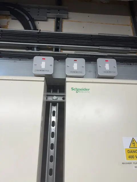 Labelled isolators installed above distribution panels in a West London plant room